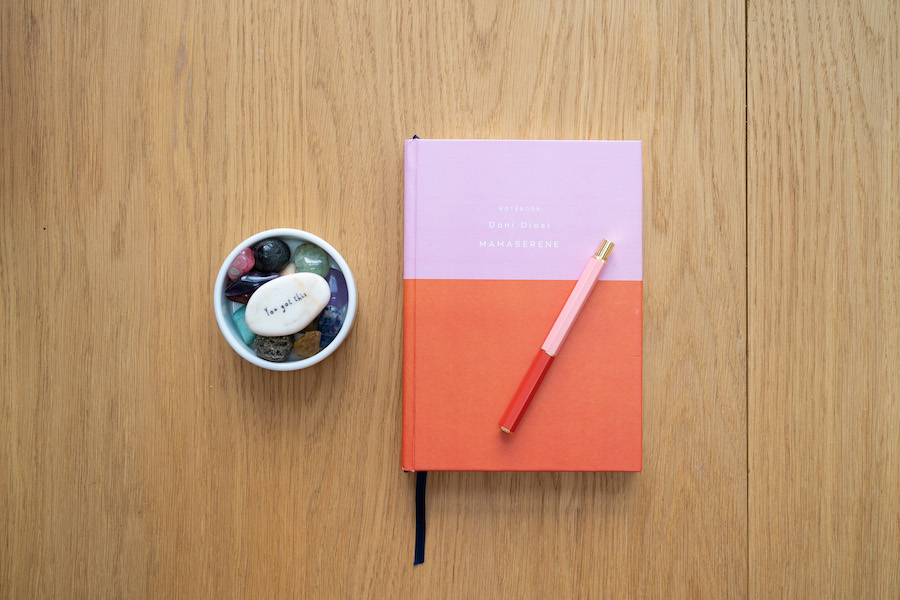 A note book in Mama Serene Brand colours and matching pen next to a bowl of crystals with the message 'you've got this' to encourage birth professionals to feel confident
